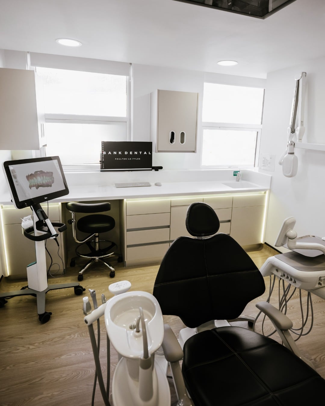 A new angle of Bank Dental Practice, a black chair in the middle of a wood-toned and white room