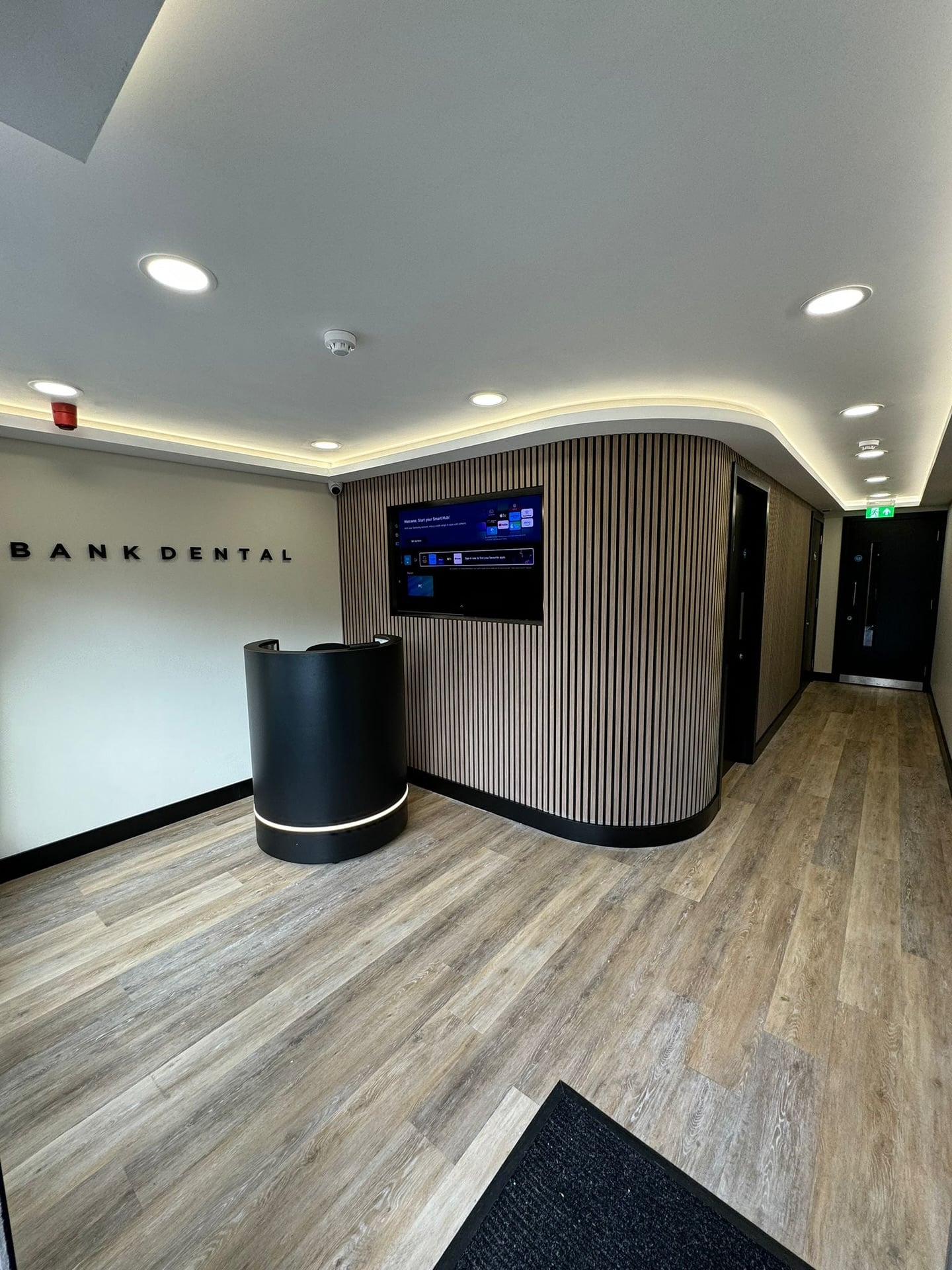 Bank Dental after Mckillop's renovation, a sleek interior with wood paneling and tiled flooring